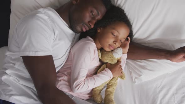 African american father and daughter sleeping together