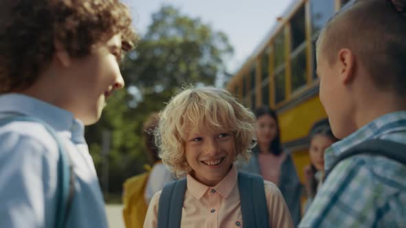 Preteen Schoolboys Stand Laughing at Bus