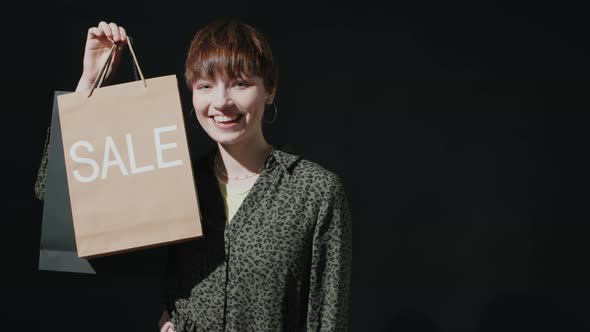 Portrait of Pretty Girl Holding Sale Shopping Bag and Smiling