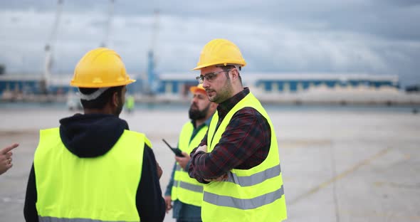 Engineer people controlling shipping containers inside industrial port