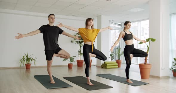 Young Diversity Sporty People Practicing Yoga Lesson with Instructor Namaste