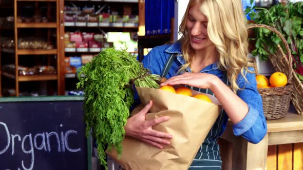 Portrait of smiling woman holding a grocery bag in organic section