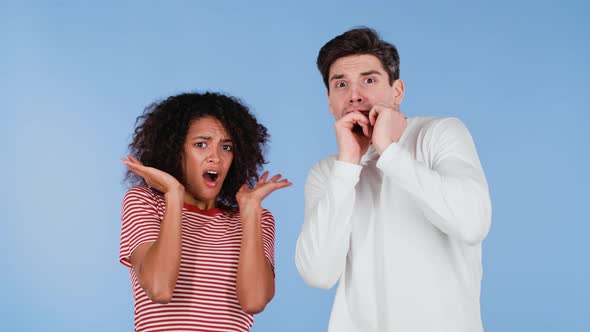 Frightened Interracial Couple Afraid of Something and Looks Into Camera with Big Eyes Full of Horror