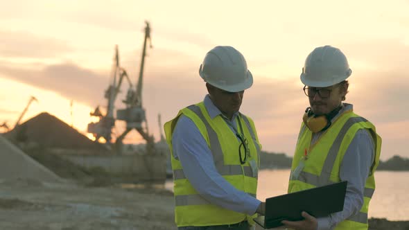 Industrial Port with Two Engineers Discussing Plans