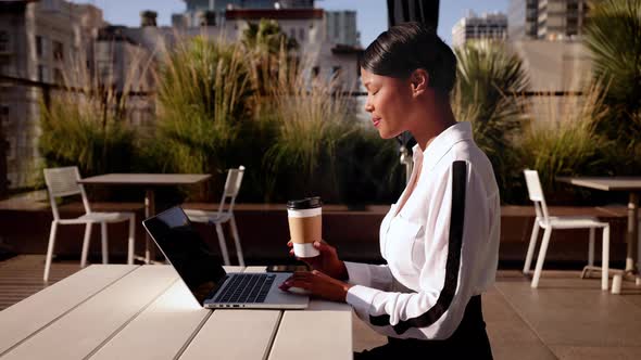 Mixed ethnicity business woman works on her laptop