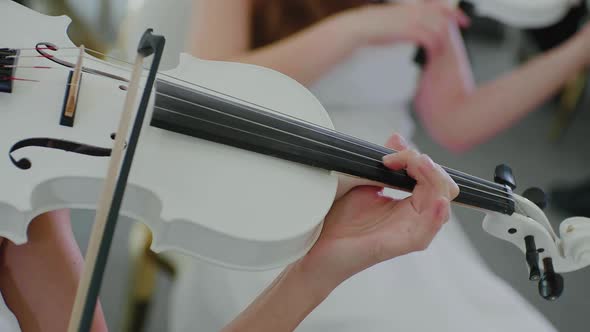 Girl in White Dress Plays on White Violin