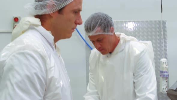 Butchers checking the weight of meat at meat factory