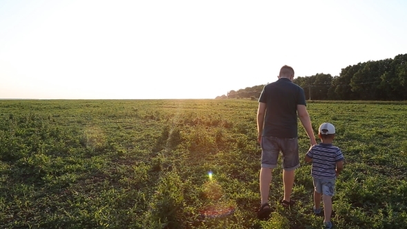 Father And Son Walking Hand In Hand Up a Hill In