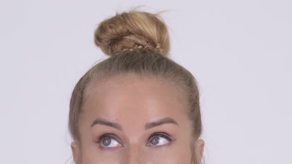 Eyes of Young Blonde Woman Thinking Against White Background