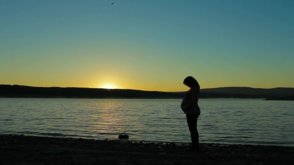Pregnant Woman Standing On The Shore