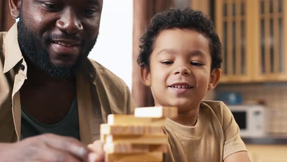 Biracial boy laughing because of falling Jenga tower