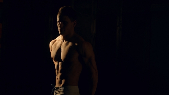 Muscular Bodybuilder Posing Over Black Background.