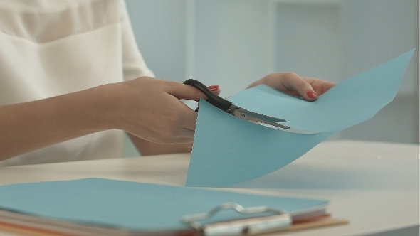 Girl Is Cutting Color Blue Paper With Scissors alt