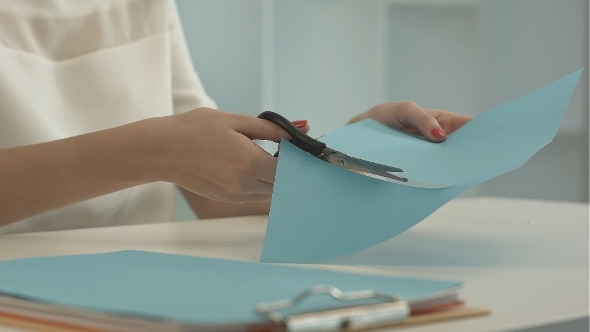 Girl Is Cutting Color Blue Paper With Scissors