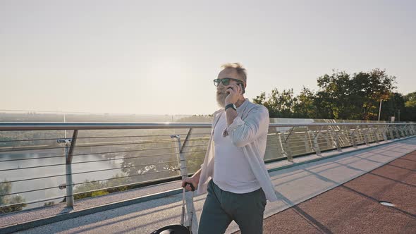 Senior Man Talks to Friend on Phone Riding Electric Unicycle