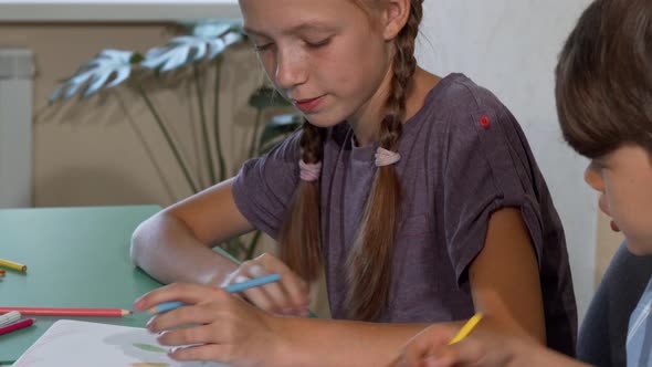 Young Girl and Boy Drawing Together in Class