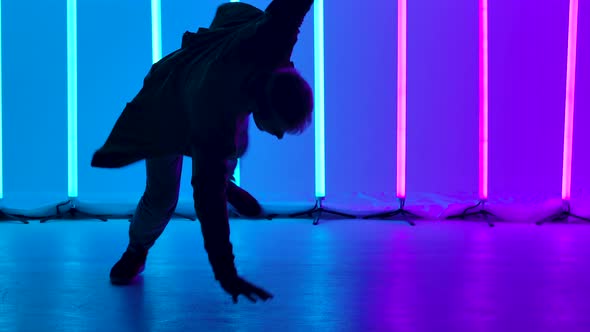 Breakdancing Acrobatic Elements Performed By a Professional Dancer Against the Backdrop of Bright