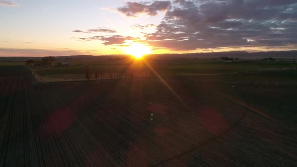 Aerial view flying towards the sun over farm field in Idaho