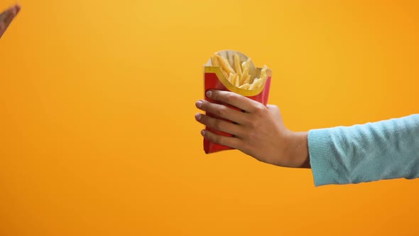 Female Hand Showing Stop Gesture on Yellow Background, Refusing Eat French Fries