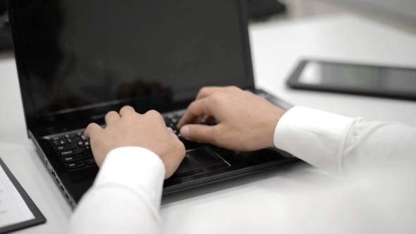 Man Typing on Laptop