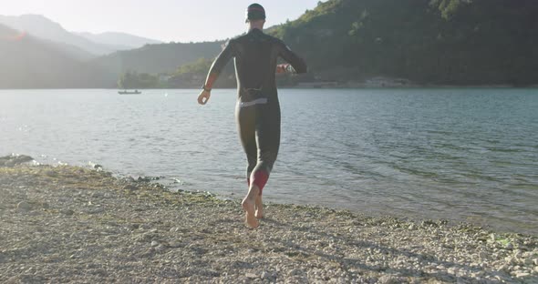 Determined Professional Triathlon Athlete in Wetsuit Start with Swimming Training for Ironman