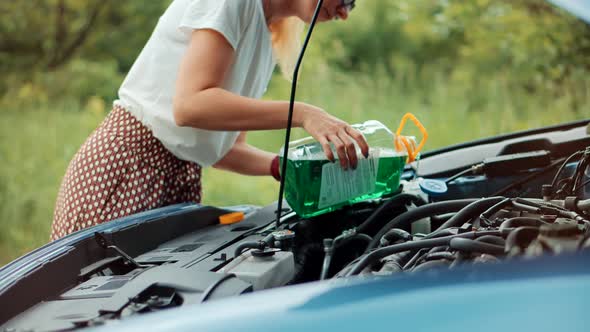 Woman Add Windshield Washer Fluid To  Vehicle. Maintenance Car Before Long Holiday Vacation Trip.