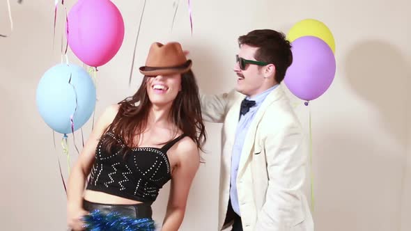 Woman and man having awesome time dancing in photo booth