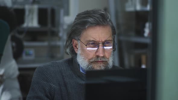 Mature Designer Browsing Computer in Studio