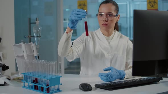 Woman Scientist Looking at Dna Substance in Test Tube