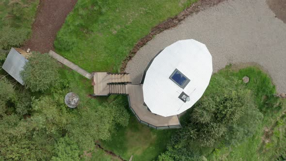 AERIAL TOP TOWN - Rising shot above a modern tiny house in Scotland