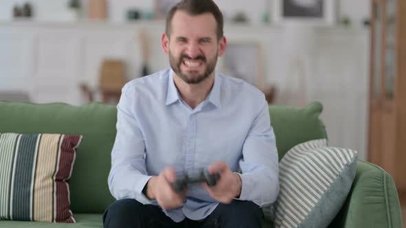 Young Man Having Loss on Video Game on Sofa