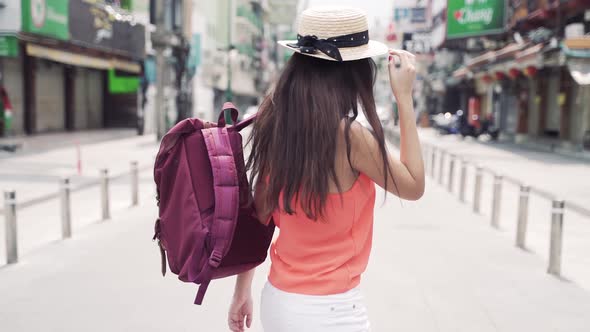 Young Brunette Woman Wearing Hat with Backpack on Vacation