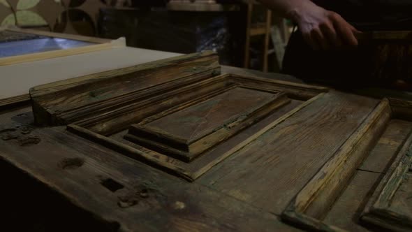 Man Brushes Old Wooden Door