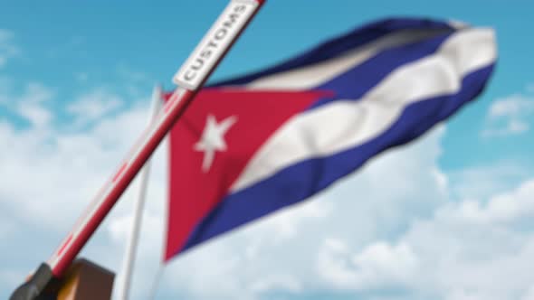 Closing Boom Barrier with CUSTOMS Sign at the Cuban Flag