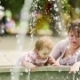 Mother And Baby Enjoying Fountains In The Park - VideoHive Item for Sale