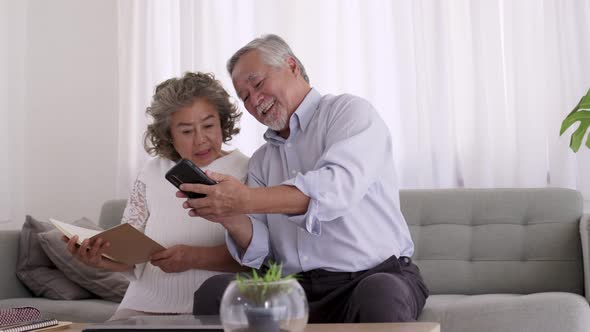 Couple Asian elderly video conferent online with smart phone in living room.