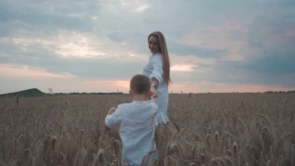 Young Cute Mother and Son in Wheat Field Countryside Nature Woman Enjoy Walks with Her Little Boy