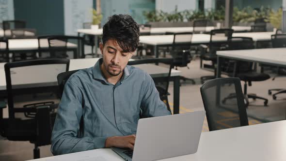 Young Man Arabian Employee Writer Thoughtfully Typing Laptop Keyboard Copying Text in Electronic