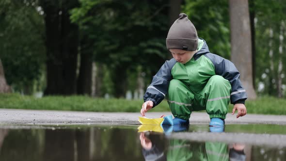 Funny Kid in Rain Boots Playing in a Rain Park