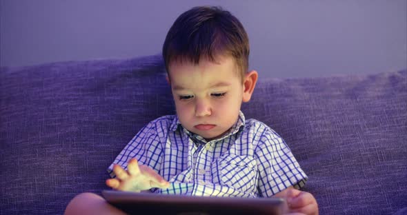 Cute Child Entertaining With Tablet