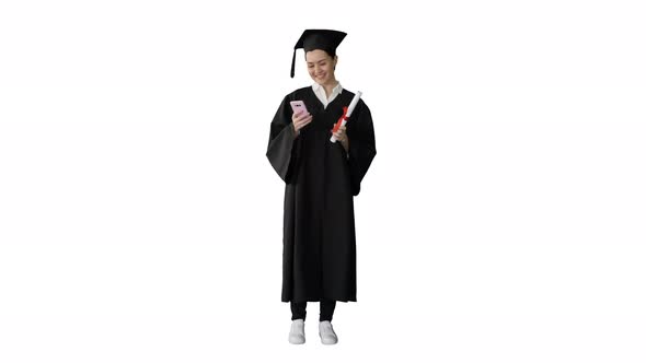 Happy Female Graduate Holding Diploma and Texting on Her Phone on White Background