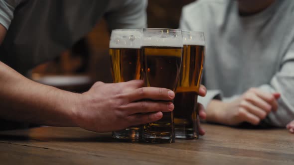 Close up of unrecognizable man bringing beer glasses for friends. Shot with RED helium camera in 8K.