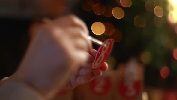 Closeup Hands of Unrecognizable Man Writing Number on Red Bag By Brush and White Paint on Blurred