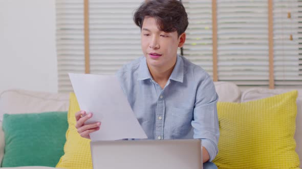 Entrepreneur handsome business asian man wear casual shirt working with laptop and look at document