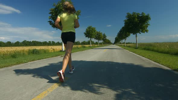 Woman Jogging on Road in Spring