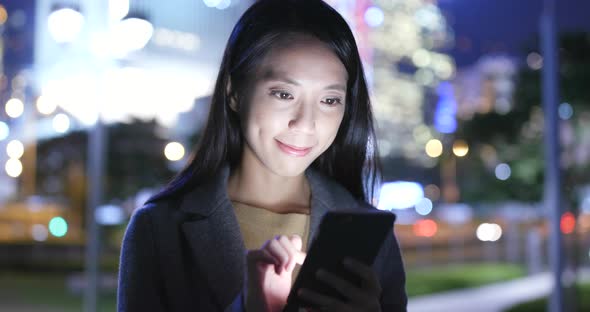 Young Woman use of mobile phone in Hong Kong at night