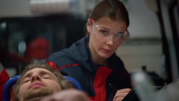 Paramedic Writing Diagnosis of Victim on Clipboard