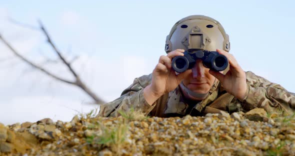Front view of military soldier looking through binoculars during military training 4k