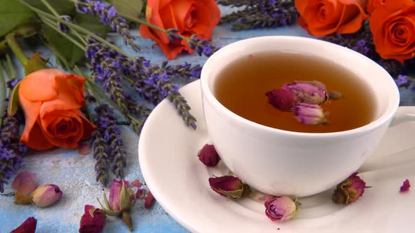 Provencal style composition: white cap of  tea with fragrant rose buds, fresh rose flowers