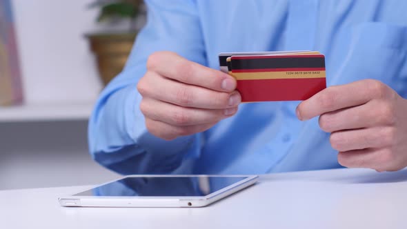 Man Shopping Online Using Digital Tablet and Gold Credit Card. Online Shopping. Close Up